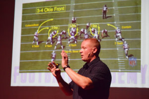 Coach Austin goes through defensive formations for the crowd. 