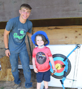 Acton Compton showed Bradley (4) how to determine eye dominance and hit the bulls eye in the Shooting Sports demonstration. Acton is a student at East View High School and is a regular competitor in archery. 