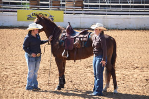 Ellen Black and Sarah Savage walk horse Jesse through a reining demo. 