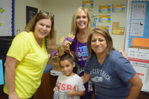 Junior Forum Fill the Bus Chair Linda Simonson and The Locker founder Karen Crosby help Annie Purl Kindergärtner Jesse Gonzales collect his first school supplies with mom Sandra. 