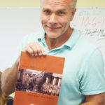 Teacher/editor Ed Straka holds up his cover art. 